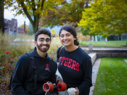 Two students smiling for camera outside.