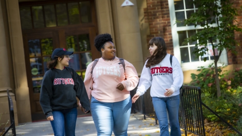 Three students walking and talking.