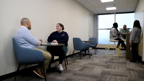 Group of people sitting and having multiple conversations.