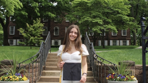 Student standing with graduation cap