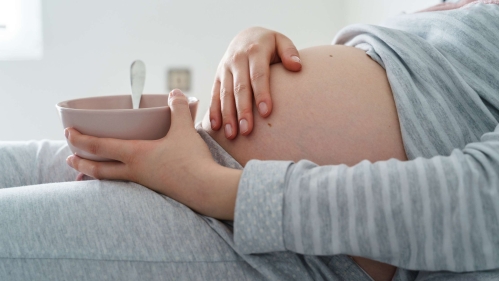 pregnant woman with a bowl of cereal