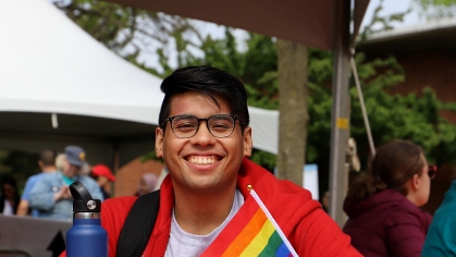 A person sitting at a table and smiling for the camera.