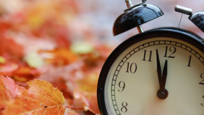 Clock on fall leaves.