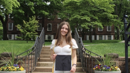Student standing with graduation cap