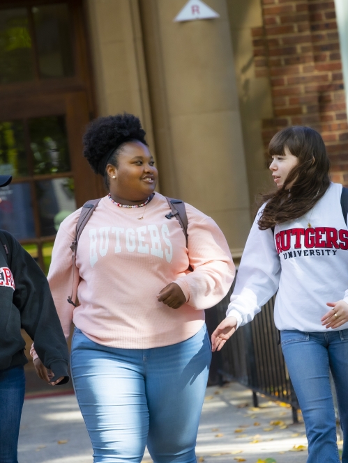 Three students walk outside Murray Hall on the College Avenue campus
