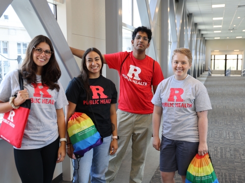 Four students looking at camera and wearing Rutgers t-shirts.