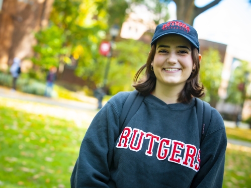 Student in Rutgers shirt and hat looking at camera