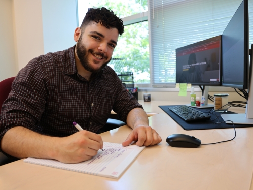 Person writing on paper at desk.