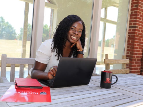 Student looking at camera with laptop.