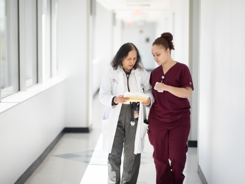 Clinical staff walking and going over notes.