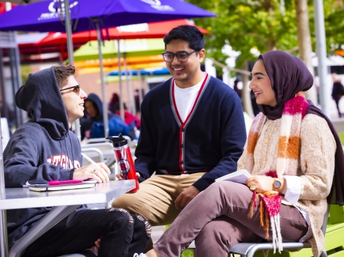 Students sitting at table and talking.