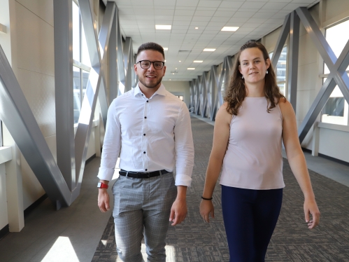 Two people walking and looking at camera