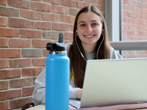 Person sitting and smiling for the camera.