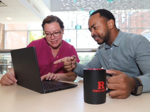Two people working together on a laptop.