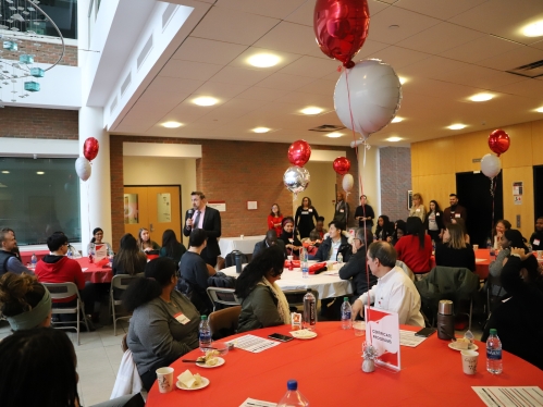 Group of people sitting at tables at a school event.