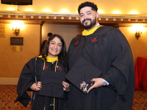 two graduates smiling at camera