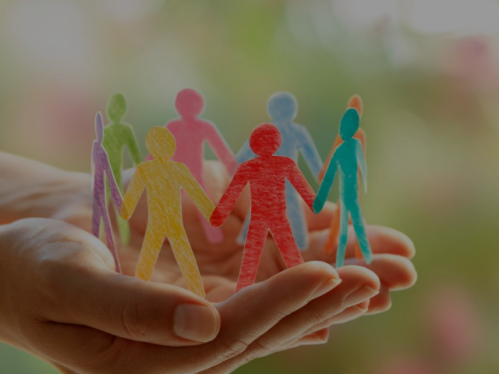 Hands holding papercut outs of people.