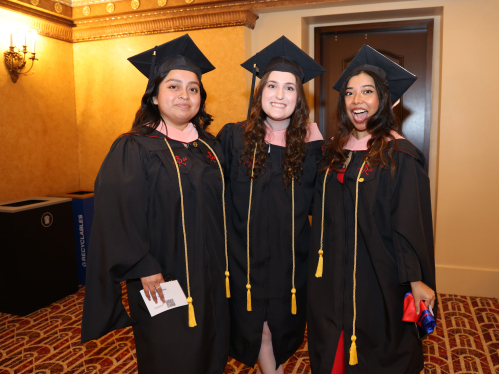 Three students in graduation attire. 