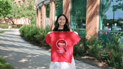 Student holding up PHocus t-shirt.