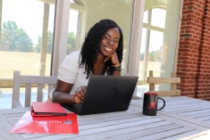 Student sitting with their laptop and SPH swag