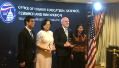 Three people holding award.