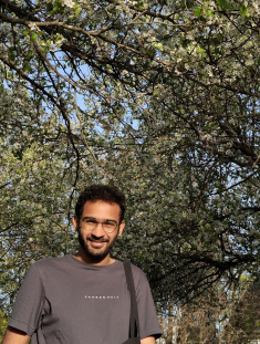 man smiling in front of trees